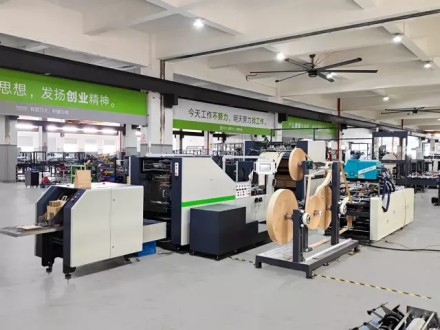 Factory floor view of paper bag machine lines with input paper rolls