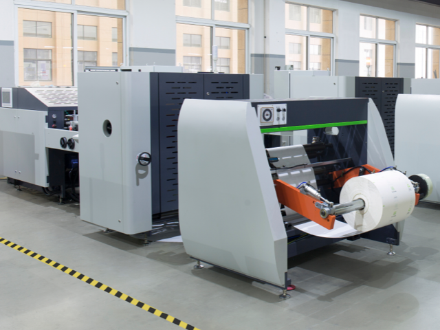 Paper bag making machine with large paper roll feed